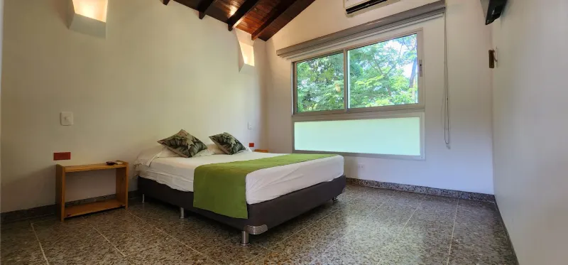 Habitación Estándar Doble Hotel Parador del Gitano - cama doble con techo de madera y vista al jardín